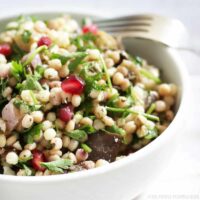 Giant Couscous Salad with roasted aubergine, parsley, and pomegranate.