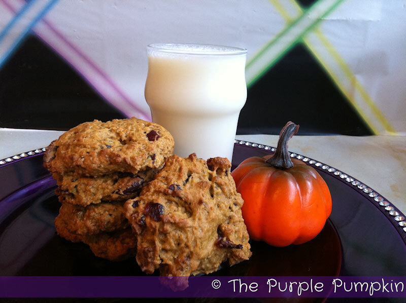 a plate of pumpkin cookies with a glass of milk