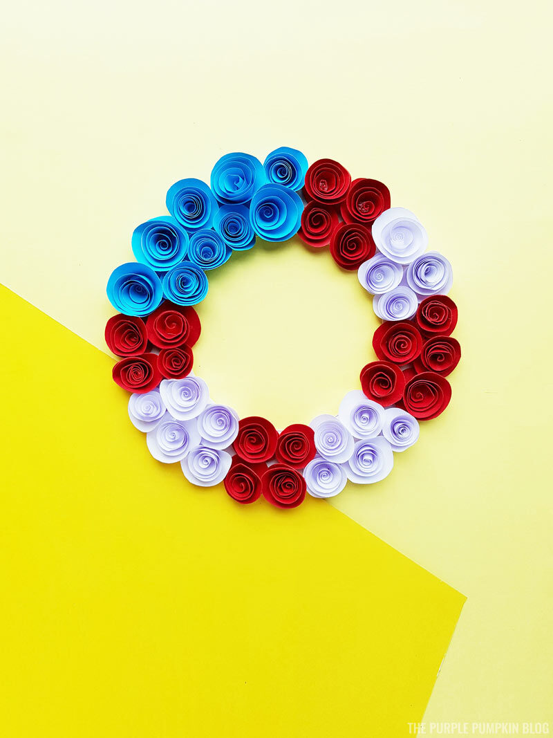 red white and blue paper roses flower wreath on a yellow background