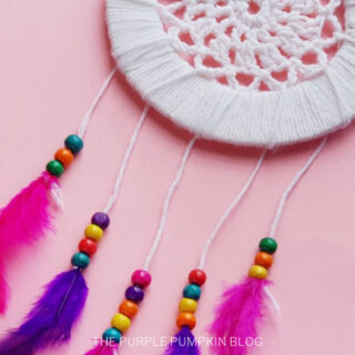 A DIY Dremcatcher with purple and pink feathers