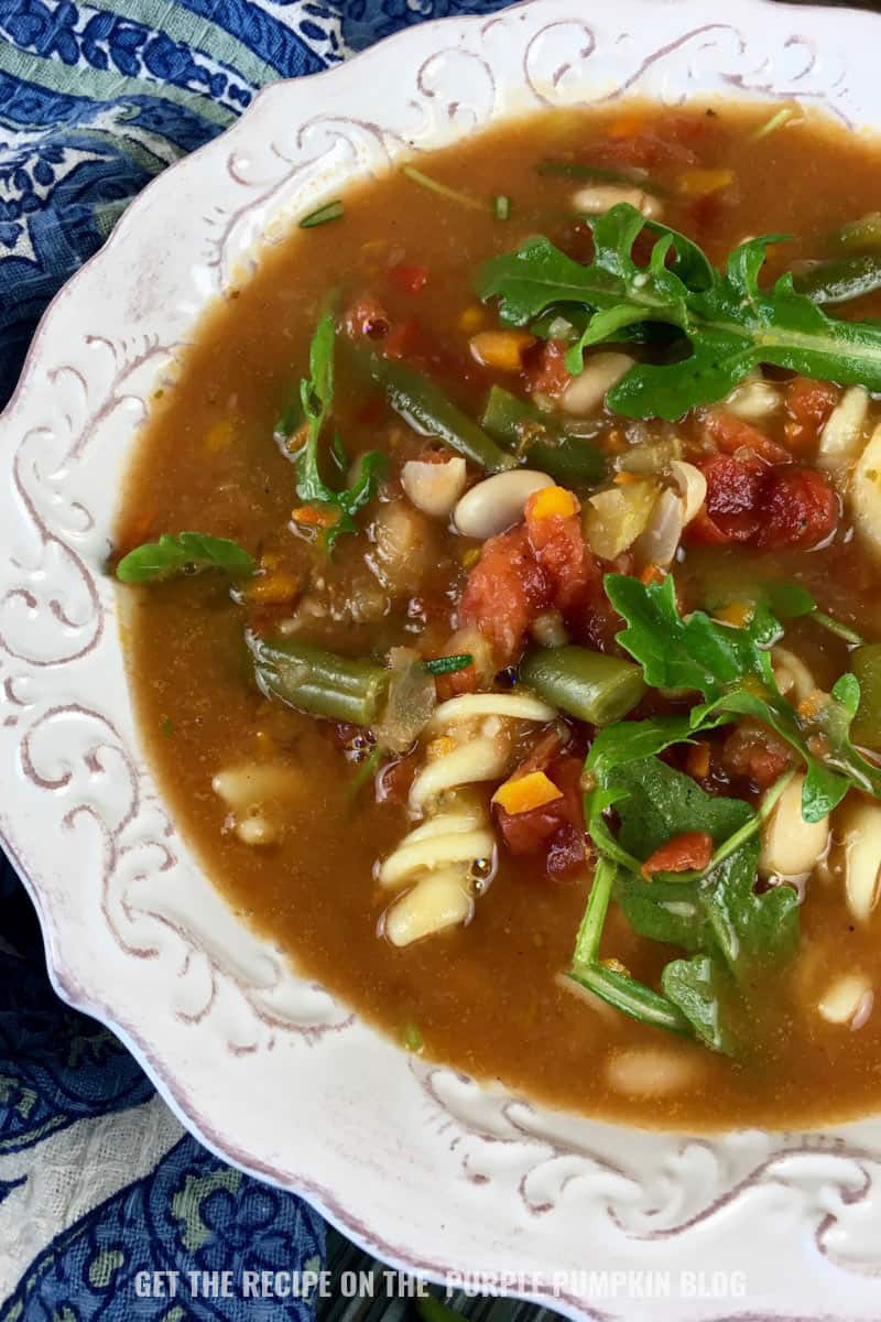 A bowl of minestrone soup with arugula