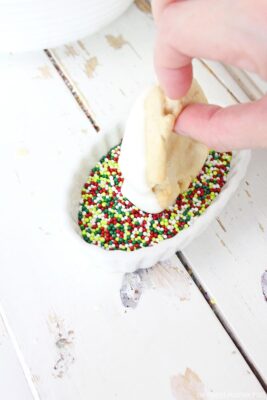 Dipping cookies into sprinkles