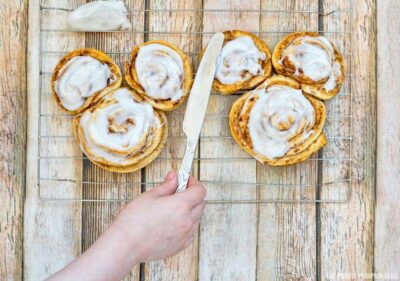Spreading bake cinnamon rolls with icin