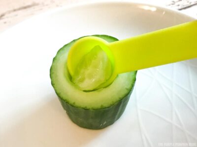 Scooping cucumber seeds out