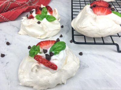 mini pavlovas topped with sliced strawberries and mini chocolate chips