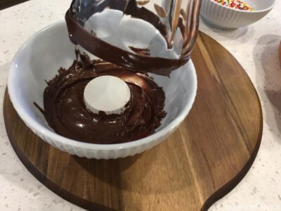 Dipping glass in melted chocolate