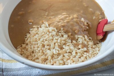 Adding melted peanut butter mix to Rice Krispies