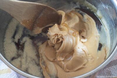 Adding peanut butter to sugar pan