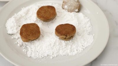 tossing cookies in powdered sugar