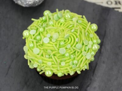 Cupcake topped with green frosting and sprinkles