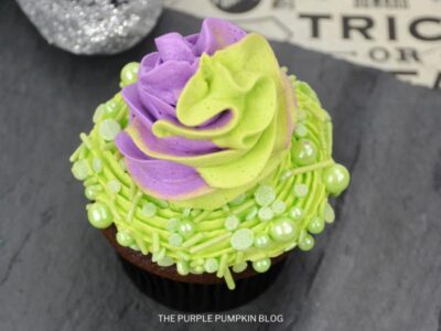 Cupcake topped with two-tone (green and purple) frosting