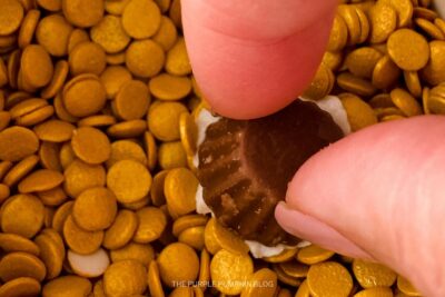 Dipping Frosted Reeses into Gold Sprinkles