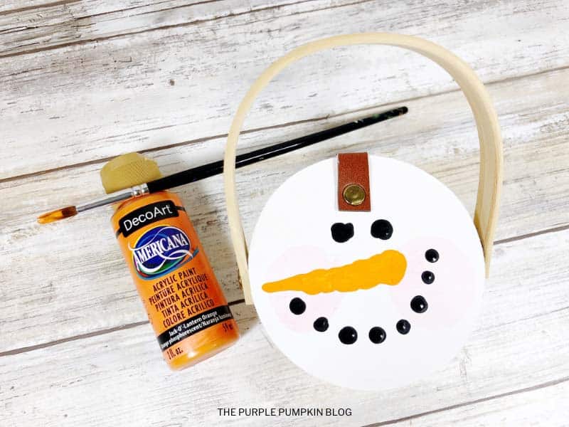 Painting Carrot Nose on Snowman's Face