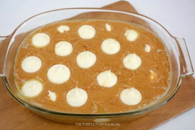 Pumpkin Earthquake Cake Batter in Baking Dish with Cream Cheese Mixture