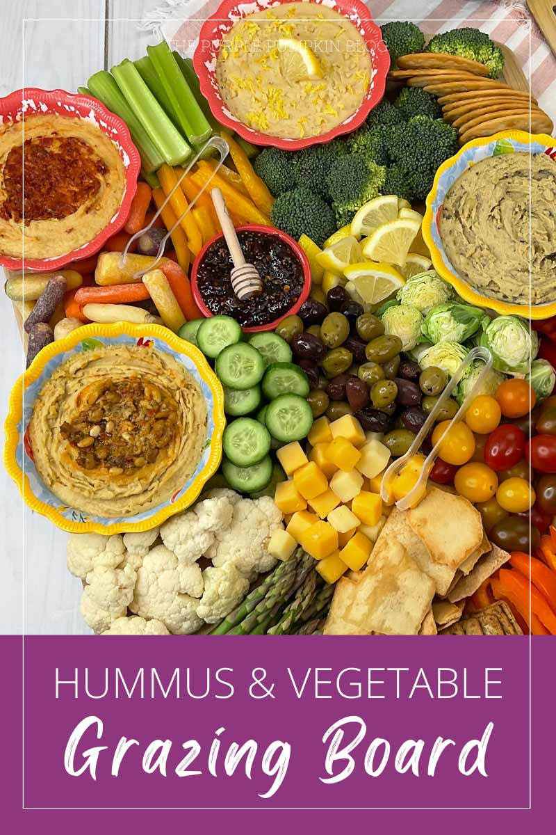 A board covered in a variety of vegetable crudite, bowls of hummus, crackers, and cheese. The text overlay says "Hummus and Vegetable Grazing Board". Similar photos of the recipe from various angles are used throughout with different text overlays unless otherwise described.