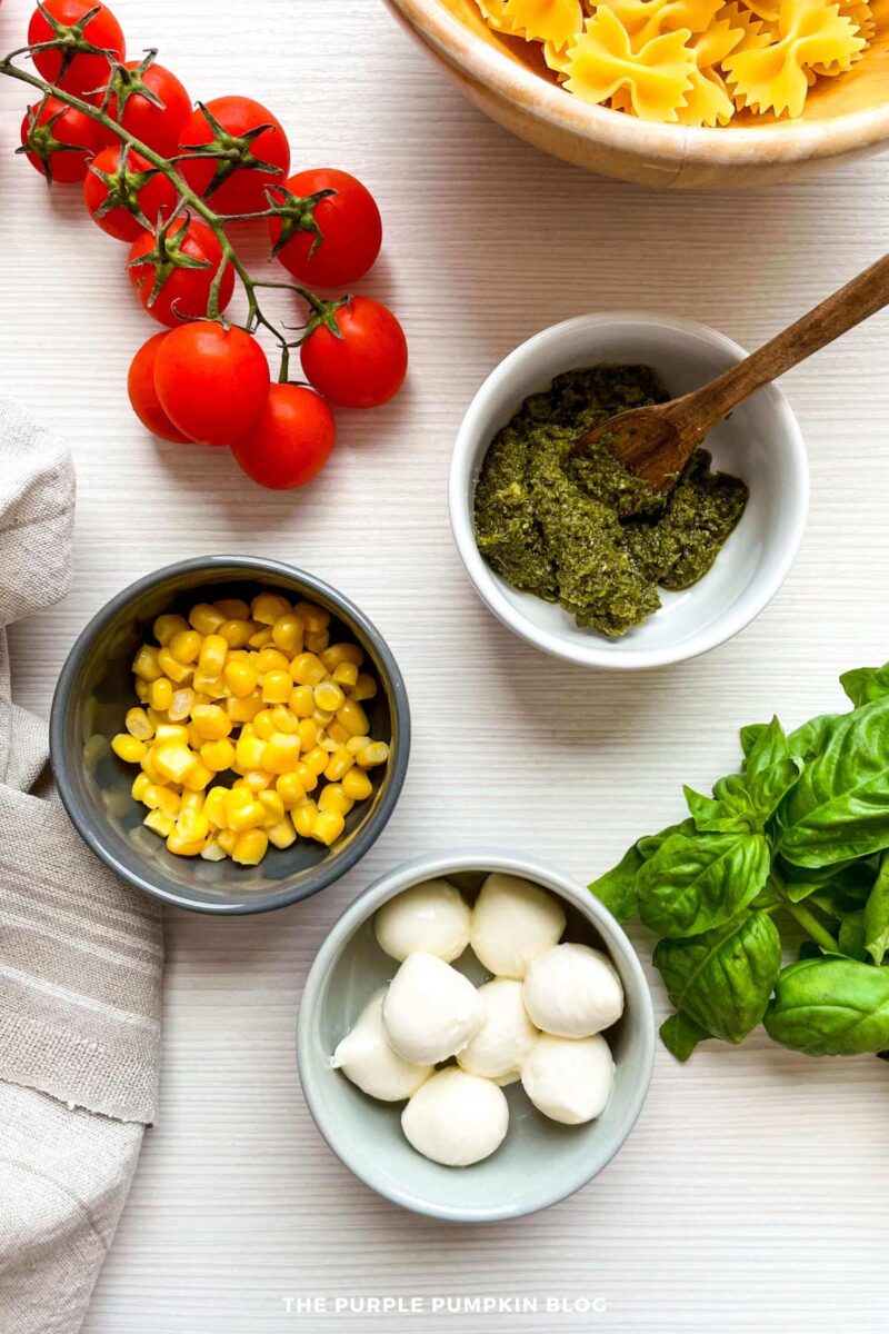 Caprese Pasta Salad Ingredients - pesto, fresh basil, sweetcorn, mozzarella pearls, vine tomatoes, bowtie pasta