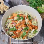 Bowl of salad - beans, corn, lettuce, bell peppers - tossed with avocado dressing and garnished with cheese and crispy tortilla strips.