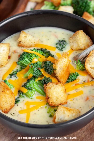 Close up of Bowl of broccoli soup garnished with additional broccoli, croutons and cheese.