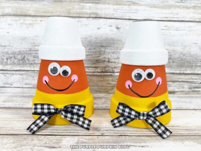 Clay pots, painted to look like candy corn, with a gingham bow and googly eyes.