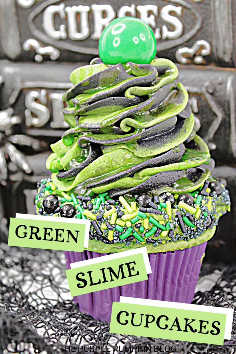 Cupcake topped with frosting and green and black sprinkles, with another swirl of black and green frosting on top with a green candy ball to finish. Halloween decor is in the background. Text overlay says: Halloween Green Slime Cupcakes