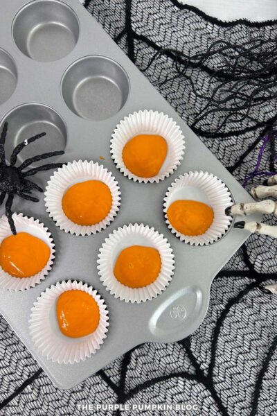 Orange Cupcake Batter Added to Cupcake Liners