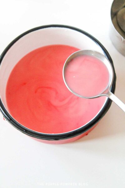 A ladle of light-red hot milk chocolate