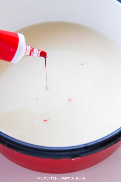 Adding red food coloring to hot chocolate mix