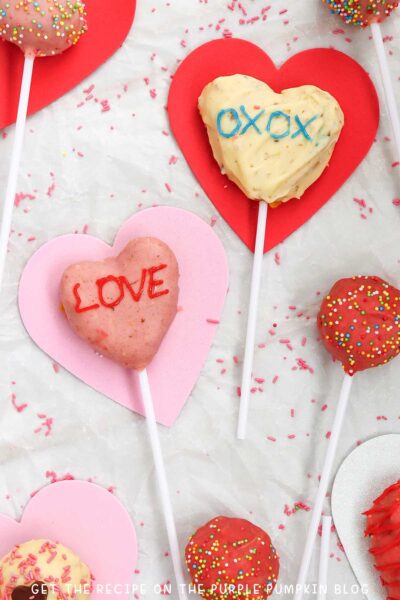 Heart-Shaped Cake Pops covered with red and white chocolate and sentiments piped on top