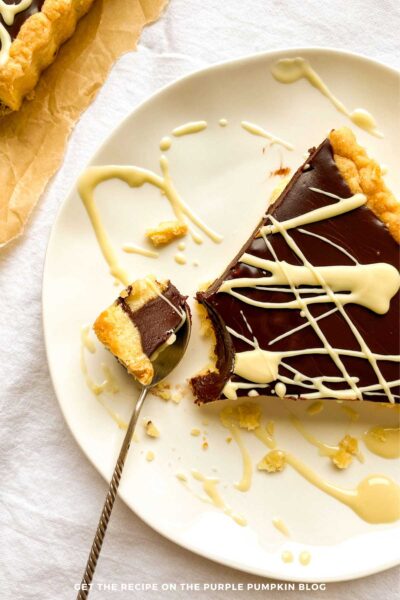 Slice of coffee chocolate tart drizzled with white chocolate.