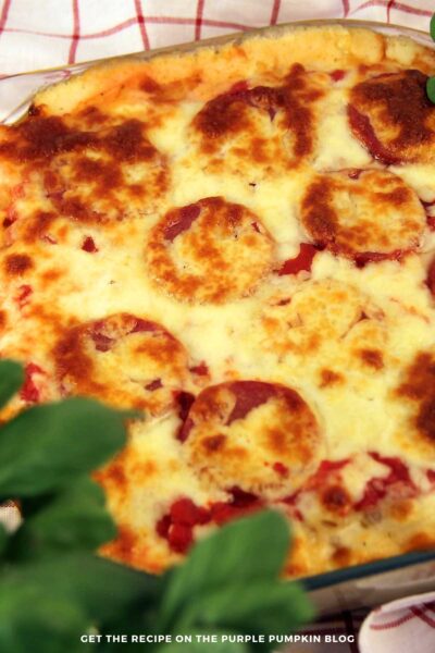 A baking dish of pizza mac and cheese topped with pepperoni and melted cheese. Text overlays says: Pizza Macaroni and Cheese with Pepperoni