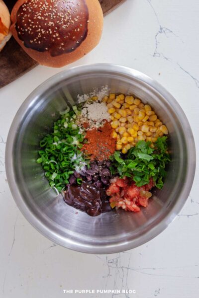 Corn, scallions, BBQ sauce, salsa, cilantro, and seasonings added to the bowl with beans