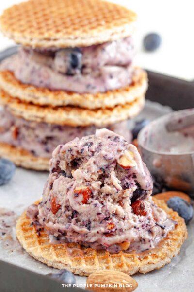 Blueberry almond ice cream sandwiched between stroopwafels with fresh blueberries and almonds on the side.