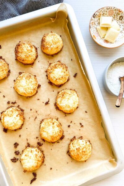 Tray of golden brown coconut macaroons fresh from the oven, edges crisped and lightly toasted.