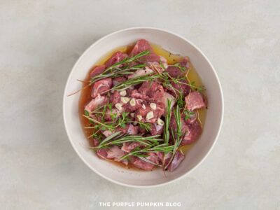 Greek souvlaki lamb marinating with herbs and spices in a bowl