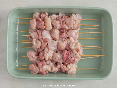 Pieces of marinated meat threaded onto wooden skewers for grilling souvlaki