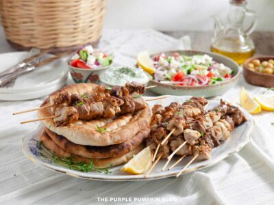 Greek souvlaki skewers served on a plate with salad and pita bread