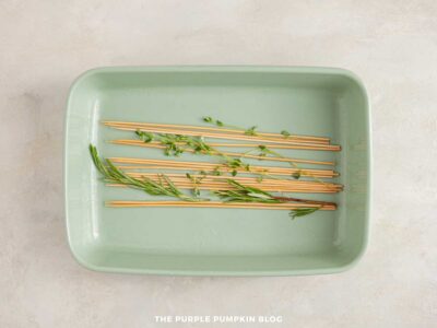 Wooden skewers soaking in a dish of water ready for making souvlaki