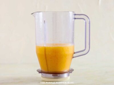 Blended mango coconut daiquiri mixture in a blender jug ready to pour