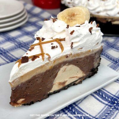 Close-up of a no-bake peanut butter banana pie slice topped with chopped peanuts and melted chocolate