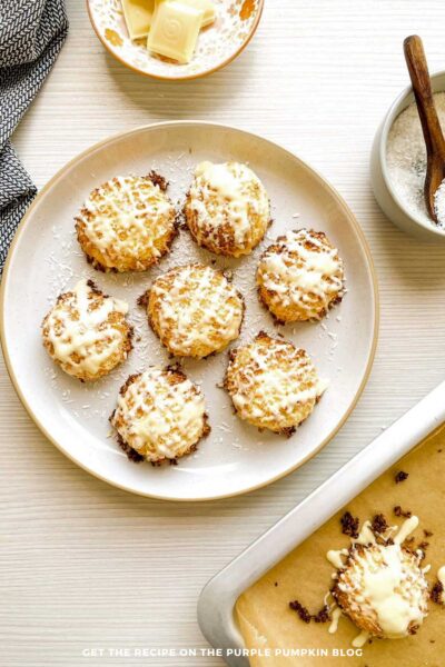 A baking sheet filled with cookies and a bowl of sugar.