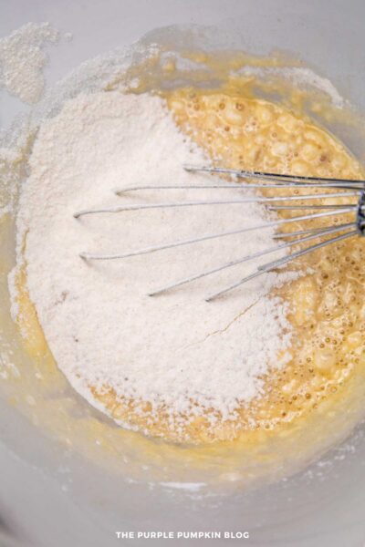 Close-up of flour and beaten eggs in a bowl, ready for baking, showing baking ingredients and process.