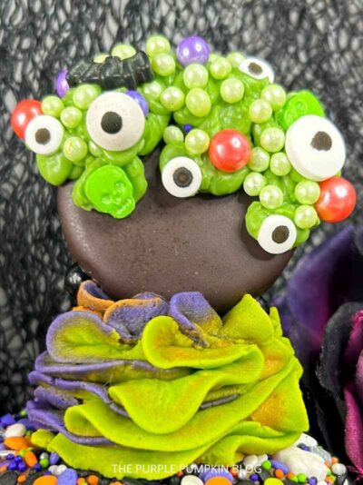 Green candy melts piped over chocolate cookie and decorated with halloween sprinkles to resemble a bubbling cauldron.