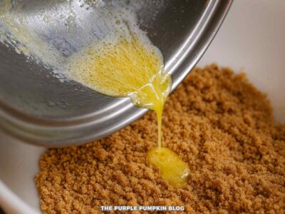 Pouring Melted Butter into Bowl of Crushed Biscuits
