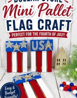 Three completed mini pallet flag crafts painted red, white, and blue. Two flags are decorated with silver glitter stars and twine bows, while the other features silver glitter letters spelling "USA." The crafts are displayed on a white wood surface with patriotic beads, greenery, and a small wooden house in the background. Text overlay says: Dollar Store Mini Pallet Flag Craft Perfect for the Fourth of July! Easy & Budget Friendly!