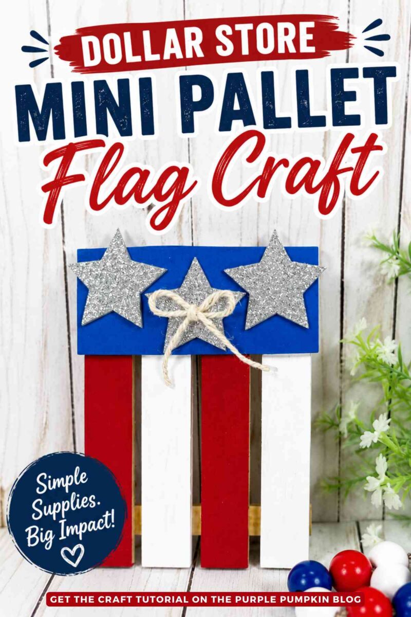A completed mini pallet flag crafts painted red, white, and blue. Decorated with silver glitter stars and twine bows. The craft is displayed on a white wood surface with patriotic beads, greenery, and a small wooden house in the background. Text overlay says: Dollar Store Mini Pallet Flag Craft. Simple Supplies. Big Impact!