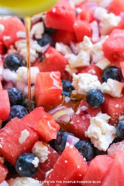 Close up of pouring olive oil onto watermelon salad