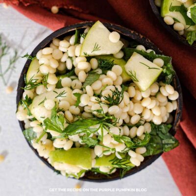 Couscous Apple Salad: Pearl couscous salad with fresh green apple, leafy greens, parsley, and dill served in a bowl.